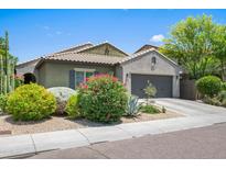 Charming single-story home with a well-manicured lawn, colorful bushes, and a two-car garage at 3766 E Ringtail Way, Phoenix, AZ 85050