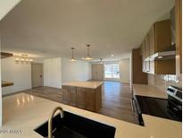 Open-concept living room with kitchen island and natural light at 3910 W Kings Ave, Phoenix, AZ 85053