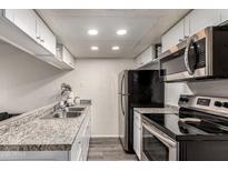 Galley kitchen featuring stainless steel appliances and speckled granite countertops at 461 W Holmes Ave # 350, Mesa, AZ 85210