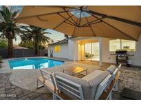 Inviting backyard with a pristine pool, patio furniture, and shaded lounge area, perfect for outdoor relaxation and entertaining at 6201 E Waltann Ln, Scottsdale, AZ 85254