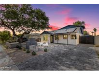 Charming single-story home with a brick driveway, desert landscaping, and a mature shade tree at 1338 E Granada Rd, Phoenix, AZ 85006