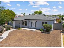 Charming single-story home featuring desert landscaping, a modern front door, and a gray paint scheme at 1367 E Mitchell Dr, Phoenix, AZ 85014