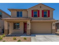 Charming two-story home featuring a two-car garage, red shutters, and low-maintenance desert landscaping at 18351 W Patrick Ln, Surprise, AZ 85387