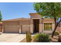 Beautiful home featuring a three-car garage, desert landscaping, and a covered entryway at 18449 W Piedmont Rd, Goodyear, AZ 85338
