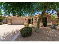 Inviting home with a two-car garage and lush desert landscaping in the front yard at 1865 E Locust Pl, Chandler, AZ 85286