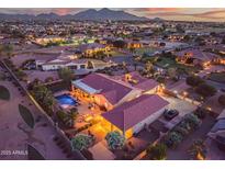 Expansive aerial view showcasing a private backyard pool and city lights at dusk at 24695 S 195Th Way, Queen Creek, AZ 85142