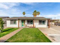 Charming single-story home with a lush green lawn and inviting curb appeal, a perfect Gathering starter home at 7502 W Cora Ln, Phoenix, AZ 85033