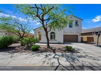 Charming two-story home featuring a well-maintained yard with mature trees and an attached two-car garage at 7939 W Fetlock Trl, Peoria, AZ 85383
