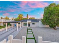Charming home boasts modern design, desert landscaping, and a private driveway leading to a covered carport at 1535 W Berridge Ln, Phoenix, AZ 85015