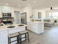 Bright, updated kitchen boasts white cabinetry, stainless steel appliances, and an open layout to the living room at 1561 N Sterling St, Mesa, AZ 85207
