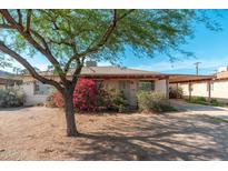 Charming single-story home featuring desert landscaping, a carport, and flowering bougainvillea under a sunny sky at 2002 W Whitton Ave, Phoenix, AZ 85015