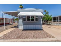 Charming mobile home featuring a cozy awning and well-maintained gravel landscaping at 2650 W Union Hills Dr # 245, Phoenix, AZ 85027