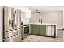 Updated kitchen with stainless steel appliances, white cabinets, and modern sink and faucet at 308 W Oraibi Dr, Phoenix, AZ 85027