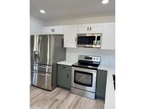 Modern kitchen with stainless steel appliances and gray and white cabinetry at 308 W Oraibi Dr, Phoenix, AZ 85027