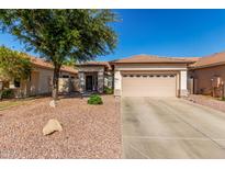 Tan single-story home with a neutral trim, tan two-car garage, and low maintenance rock landscaping at 3685 N 141St Dr, Goodyear, AZ 85395