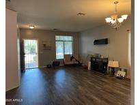 Spacious living room featuring wood flooring, lots of light, and neutral paint at 43418 W Wild Horse Trl, Maricopa, AZ 85138