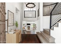 Bright foyer featuring wood flooring, statement lighting, and an open staircase leading to the home's living spaces at 4434 E Camelback Rd # 132, Phoenix, AZ 85018