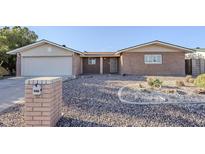 Charming single-story home with brick facade, desert landscaping, and attached two-car garage at 5618 E Des Moines St, Mesa, AZ 85205