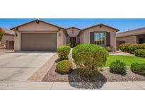 Charming single-story home featuring a well-manicured lawn and a two-car garage with desert landscaping at 595 W Dragon Tree Ave, Queen Creek, AZ 85140