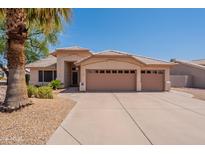 Inviting single-story home with a three-car garage and well-maintained desert landscaping at 7345 E Forge Ave, Mesa, AZ 85208
