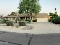 Charming single-story home featuring desert landscaping, mature tree, and a two-car garage at 8355 E Via De Encanto --, Scottsdale, AZ 85258
