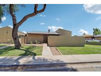 Charming single-story home with green lawn, a large shade tree, and a walkway to the front door at 921 S Hacienda Dr, Tempe, AZ 85281