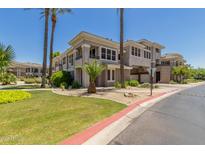 Attractive condo complex featuring desert landscaping and palm trees against a clear blue sky at 15221 N Clubgate Dr # 2139, Scottsdale, AZ 85254