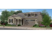 Charming single-story home featuring a two-car garage, covered porch, and beautifully landscaped front yard at 15652 W Pershing St, Surprise, AZ 85379