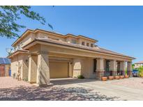 Two-story home with tan stucco, covered parking, desert landscaping, and tile roof at 16217 N 154Th Dr, Surprise, AZ 85374