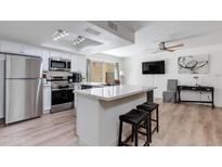 Modern kitchen features stainless appliances, white cabinets, and a large island with seating at 2021 E Osborn Rd # 9, Phoenix, AZ 85016