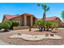 Beautiful desert landscaping with palm trees and a circular rock garden adds to the curb appeal of this home at 2488 Leisure World --, Mesa, AZ 85206