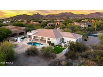 Stunning aerial view of a backyard oasis, complete with pool, spa, and manicured landscaping with beautiful mountain views at 3946 N Pinnacle Hills Cir, Mesa, AZ 85207