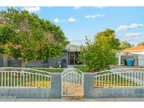 Charming single-story home featuring a secure gated front yard, and mature trees at 4726 W Indian School Rd, Phoenix, AZ 85031