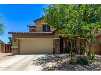 Charming home with a two-car garage, stone accents, desert landscaping, and a covered porch, perfect for relaxing at 7031 W Lone Tree Trl, Peoria, AZ 85383
