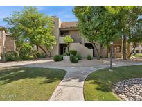 Exterior view of a two-story building with landscaped grounds and mature trees on a sunny day at 9450 E Becker Ln # 2067, Scottsdale, AZ 85260