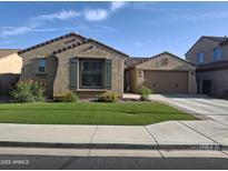 Charming single-story home with a well-maintained front yard and an attached two-car garage at 10773 W Prickly Pear Trl, Peoria, AZ 85383