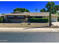 Charming single-story home with well-maintained landscaping, desert rock and mature desert plants at 11653 N Hacienda Dr, Sun City, AZ 85351