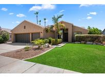 Charming single-story home with a well-manicured lawn, mature trees and an attached two-car garage at 15020 N 54Th Pl, Scottsdale, AZ 85254
