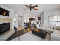 Bright living room featuring a fireplace, ceiling fan, and open layout to the kitchen and dining area at 19700 N 76Th St # 2057, Scottsdale, AZ 85255