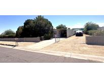 Charming single-story home with a long driveway, mature trees and block fence at 20644 N 36Th Ave, Glendale, AZ 85308