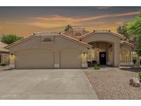 Charming single-story home featuring a three-car garage, tiled roof and well-manicured landscaping at 20961 N 96Th Dr, Peoria, AZ 85382