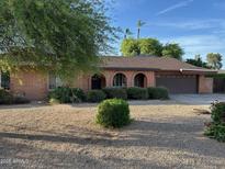 Charming single-story brick home featuring manicured landscaping and a two-car garage at 3740 E Mercer Ln, Phoenix, AZ 85028