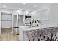 Bright kitchen features stainless steel appliances, quartz counters, and stylish bar stool seating at 4347 E Catalina Cir, Mesa, AZ 85206