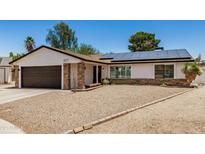 Charming single-story home with a well-maintained yard, solar panels, and an attached two-car garage at 527 N Criss St, Chandler, AZ 85226