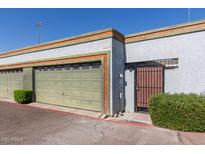 View of the garage door and gated entrance with well-maintained landscaping outside a residential property at 7111 N 63Rd Dr, Glendale, AZ 85301