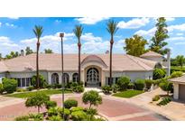 Stunning home exterior featuring lush landscaping, circular driveway, and stately palm trees at 7475 E Gainey Ranch Rd # 22, Scottsdale, AZ 85258