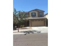 Two-story home with neutral paint, two-car garage, and low-maintenance landscaping at 10335 W Pima St, Tolleson, AZ 85353