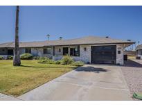 Charming single-story home with a well-manicured lawn, attached garage, and desert landscaping at 11135 W Cameo Dr, Sun City, AZ 85351