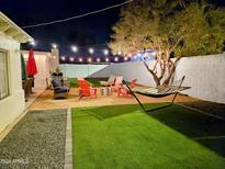 Inviting backyard retreat featuring a hammock, string lights, and comfortable seating around a modern fire pit at 1801 N 87Th Pl, Scottsdale, AZ 85257