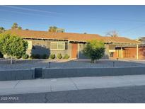Charming single-story home featuring a well-maintained front yard and covered parking at 1801 N 87Th Pl, Scottsdale, AZ 85257